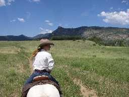 Wrangler leads way to the stockade on circle ride, Tooth of Time in background
